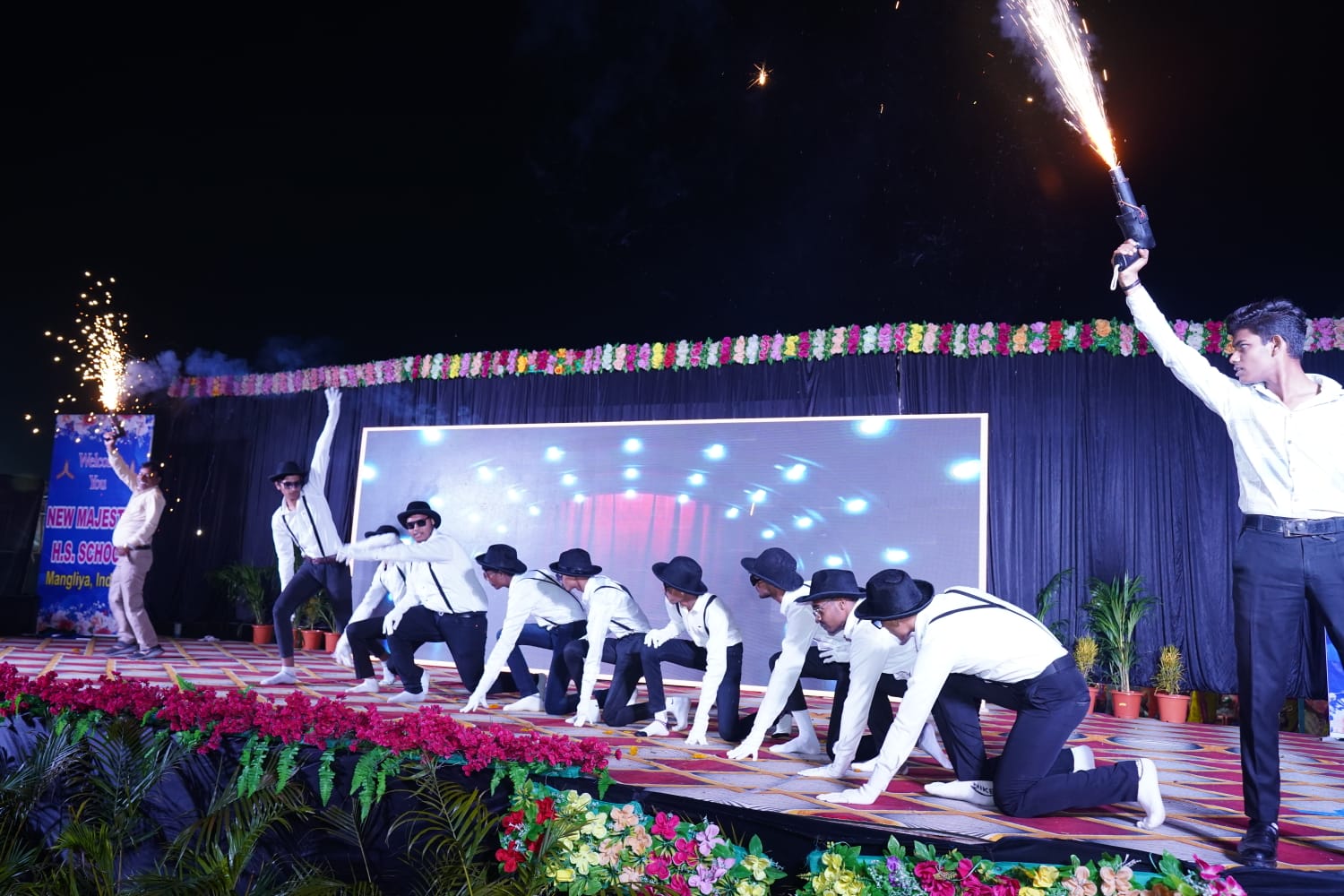 Students performing musical pieces on stage with a live audience at the school music concert.