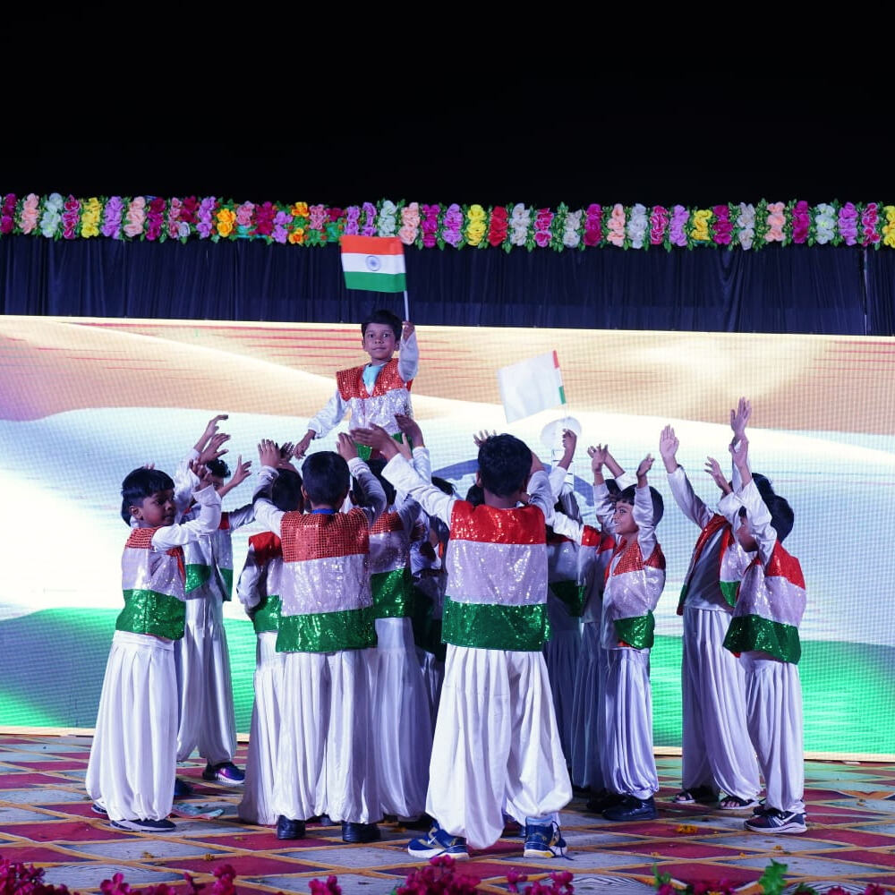 Students performing musical pieces on stage with a live audience at the school music concert.