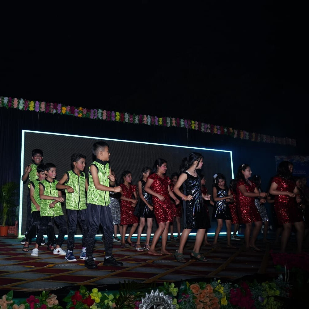 Students performing musical pieces on stage with a live audience at the school music concert.